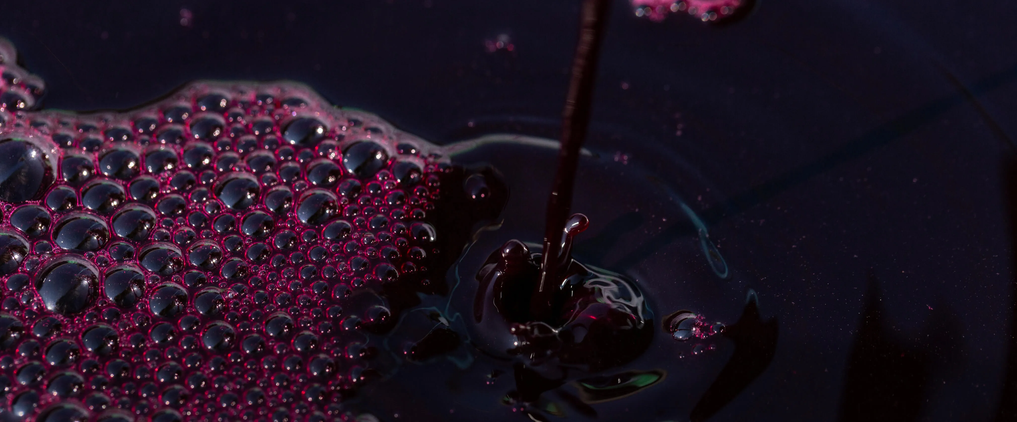 Red wine pouring into a barrel, with rich red bubbles